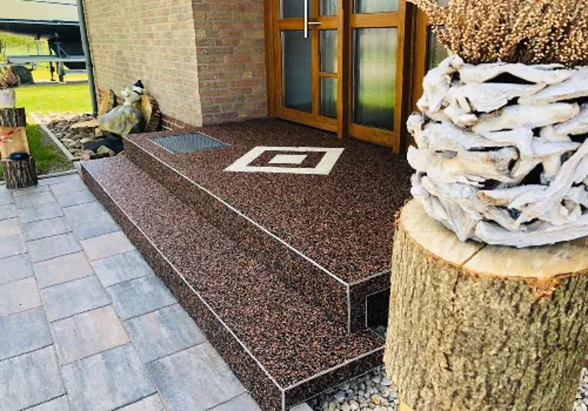 Braune Steinteppich-Treppe und Eingangsbereich mit weißem Muster